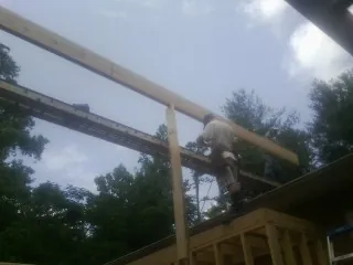 Carpenter setting a ridge beam over a new addition frame — Ice Dam Removal by Roofing Brothers in Saint Meinrad