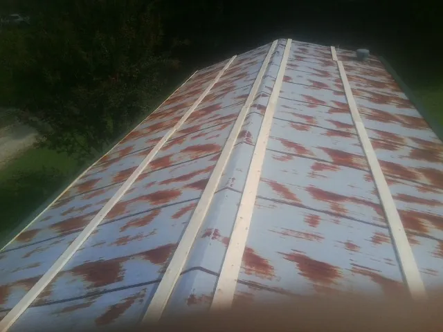 Rusted metal roof panels with new wood purlins before replacement — Storm Damage Roof Repair in Saint Meinrad by Roofing Brothers