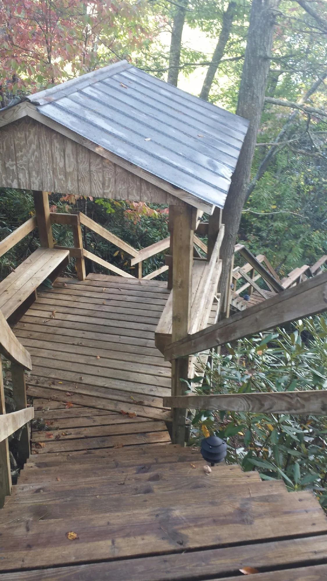 Metal roofed shelter over wooden steps on a wooded walkway — Skylight Repair & Installation work by our crew in Saint Meinrad
