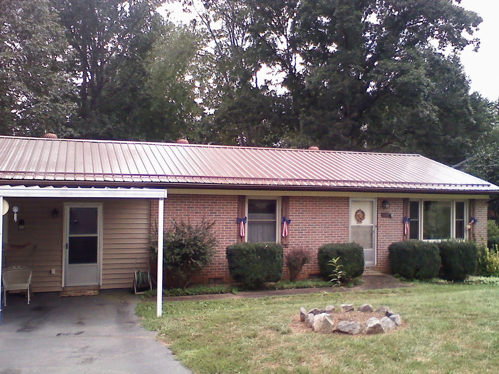Bronze metal roof and carport on a brick ranch home — Roof Repair work by our crew in Saint Meinrad